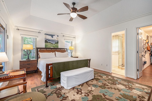 bedroom featuring crown molding, multiple windows, wood finished floors, and a raised ceiling
