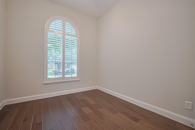 unfurnished room with baseboards, dark wood-style floors, and a healthy amount of sunlight