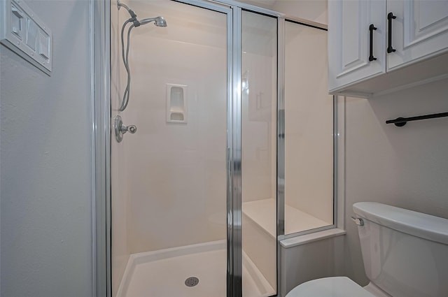 bathroom featuring a stall shower and toilet