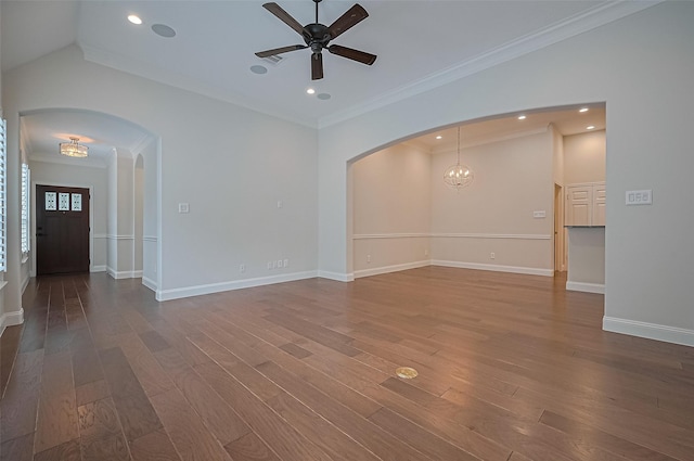 unfurnished living room featuring arched walkways, wood finished floors, and ceiling fan with notable chandelier