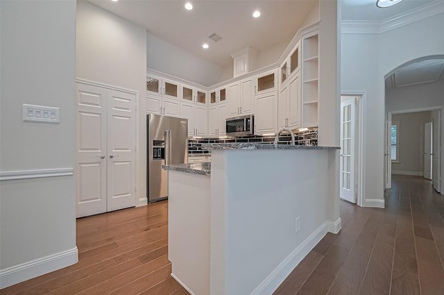 kitchen with white cabinets, stainless steel appliances, visible vents, and wood finished floors