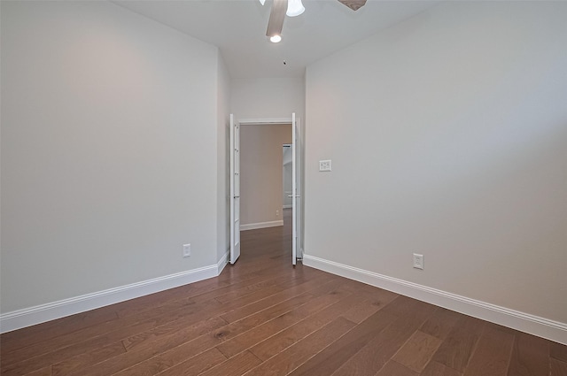 empty room featuring baseboards, a ceiling fan, and dark wood-style flooring