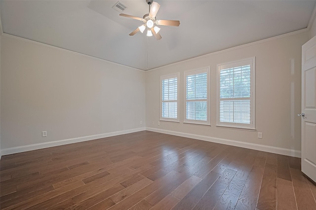 spare room with ceiling fan, dark wood-style flooring, visible vents, crown molding, and baseboards
