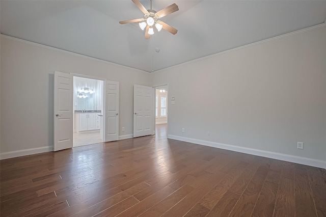 empty room with crown molding, lofted ceiling, baseboards, ceiling fan, and dark wood finished floors