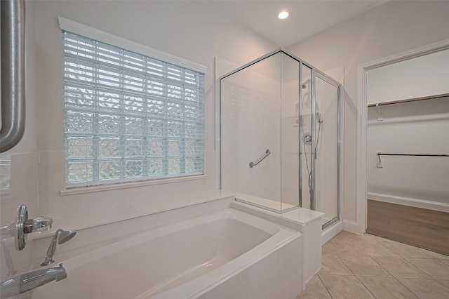 bathroom featuring a bath, a shower stall, tile patterned floors, a spacious closet, and recessed lighting