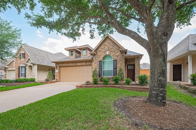 view of front of house with driveway, roof with shingles, a front yard, a garage, and brick siding