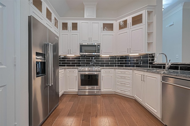 kitchen featuring white cabinets, appliances with stainless steel finishes, a sink, and wood finished floors