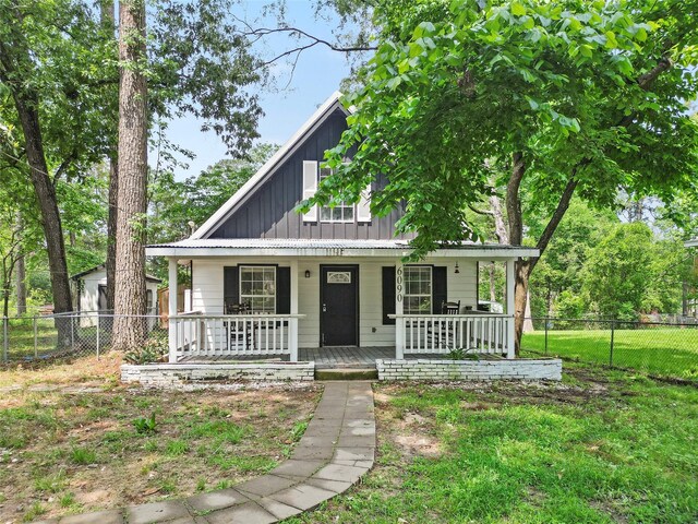 6090 Skylane Dr, Montgomery, TX 77316 - view of front of house featuring board and batten siding, fence, and a porch