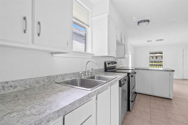 6090 Skylane Dr, Montgomery, TX 77316 - kitchen featuring white cabinets, a sink, stainless steel appliances, a peninsula, and light tile patterned floors