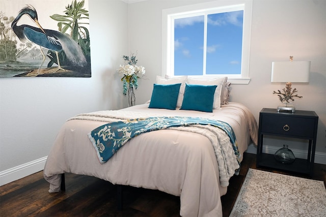 bedroom with baseboards and wood finished floors