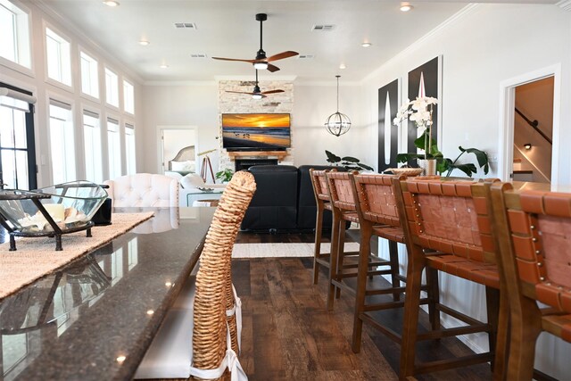 dining room with ornamental molding, a ceiling fan, dark wood finished floors, and visible vents