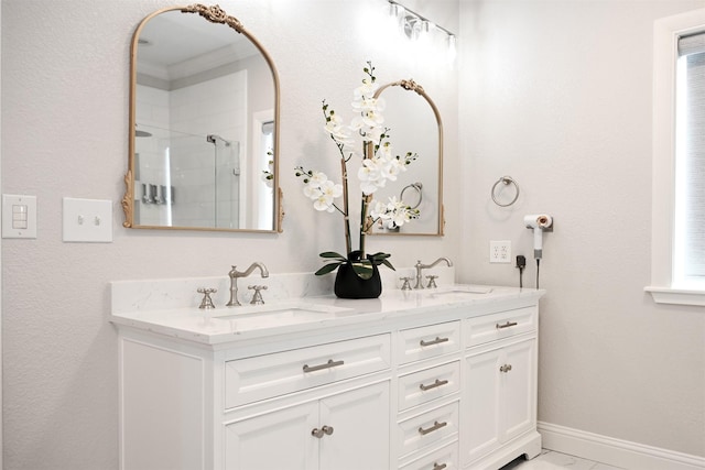 bathroom featuring double vanity, a sink, baseboards, and a stall shower