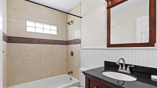 bathroom with vanity, shower / bathing tub combination, wainscoting, and toilet