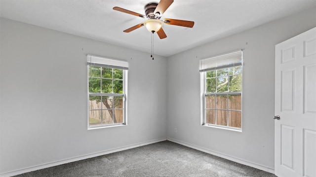 carpeted empty room with baseboards and ceiling fan