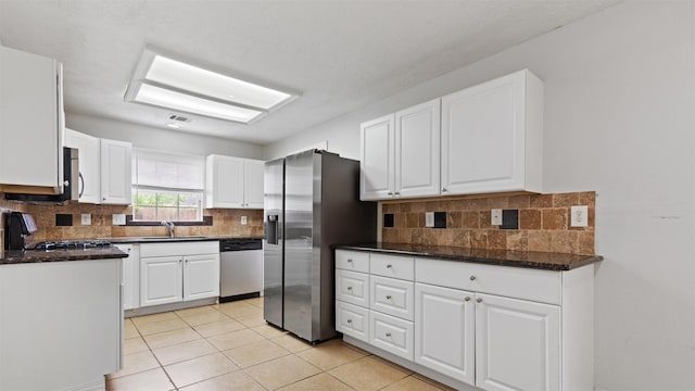 kitchen featuring visible vents, white cabinetry, tasteful backsplash, a sink, and stainless steel appliances