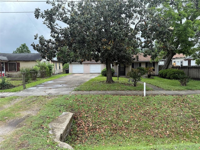 4300 Weaver Rd, Houston, TX 77016 - obstructed view of property featuring concrete driveway, fence, a front lawn, and a garage