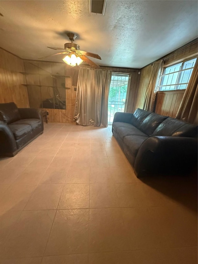 4300 Weaver Rd, Houston, TX 77016 - living area featuring a ceiling fan, wood walls, and a textured ceiling