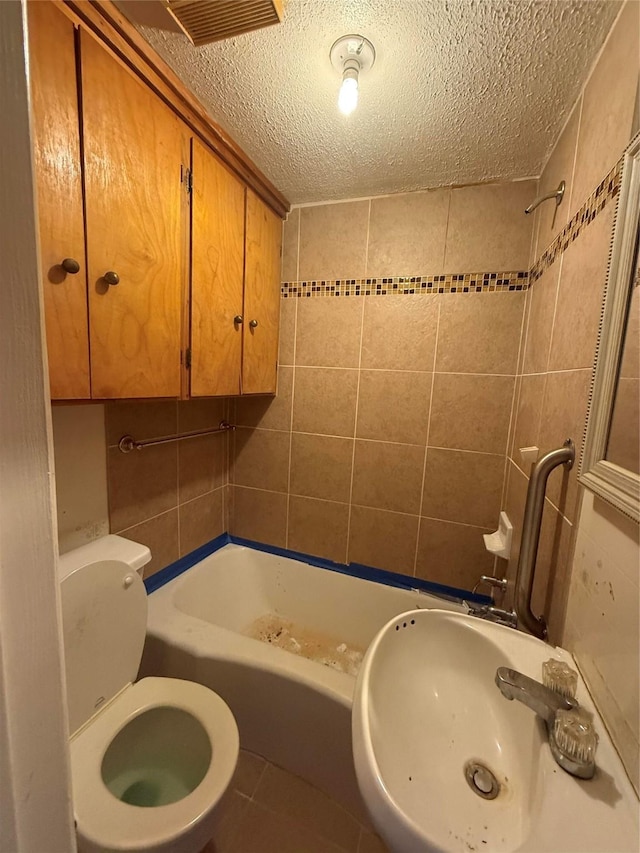 4300 Weaver Rd, Houston, TX 77016 - bathroom featuring visible vents, tile patterned flooring, toilet, a textured ceiling, and a sink