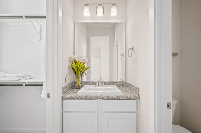 453 Stratus View Ct, Katy, TX 77493 - bathroom with a walk in closet, vanity, and toilet