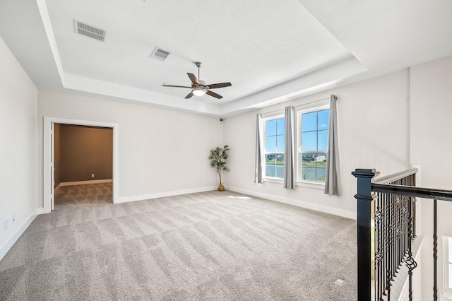 453 Stratus View Ct, Katy, TX 77493 - carpeted spare room with visible vents, a ceiling fan, and a tray ceiling