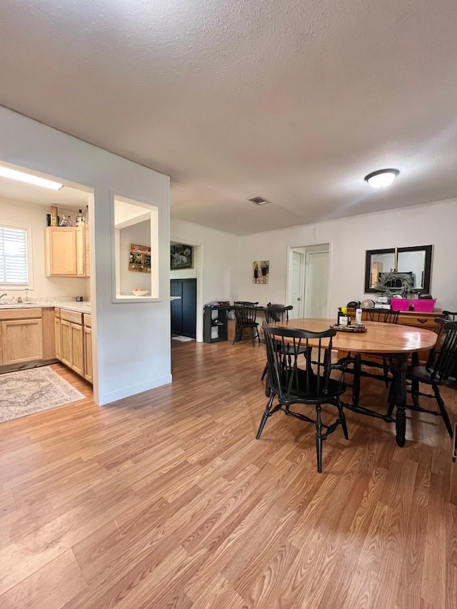 dining area featuring light wood-type flooring and visible vents