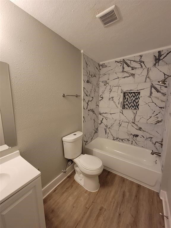 bathroom with visible vents, vanity, wood finished floors, toilet, and a textured ceiling