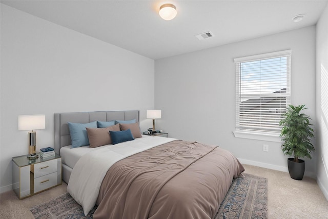 bedroom with visible vents, baseboards, and light carpet