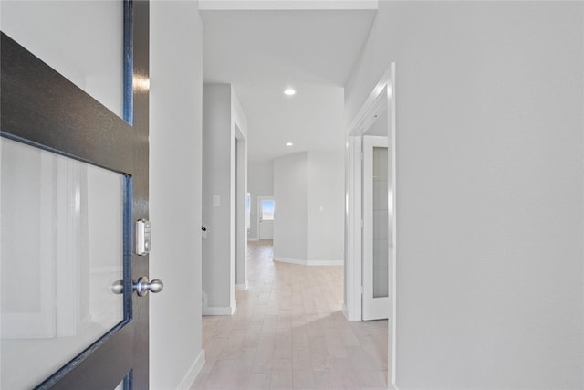 hall with light wood-style floors, recessed lighting, and baseboards