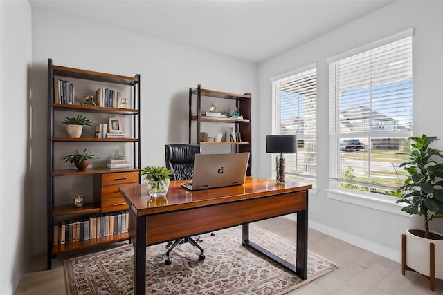 office space featuring baseboards and a wealth of natural light