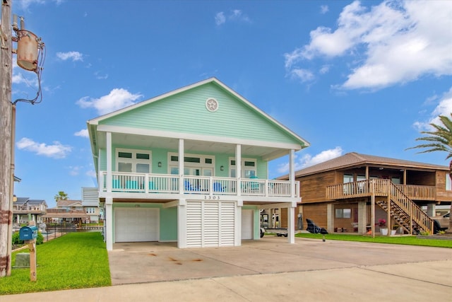 1303 Blue Heron St, Bayou Vista, TX 77563 - raised beach house featuring stairs, an attached garage, concrete driveway, and a porch