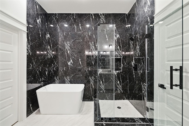 bathroom featuring tile walls, a freestanding bath, a marble finish shower, and marble finish floor