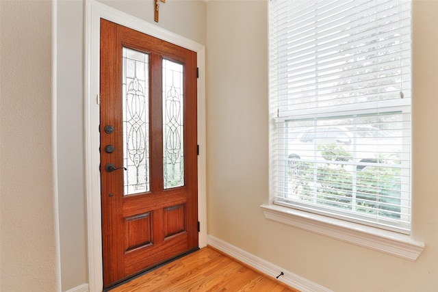 foyer entrance with baseboards and light wood-style flooring
