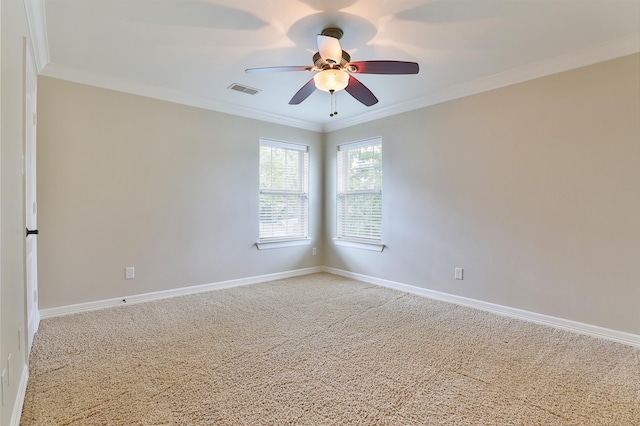spare room with crown molding, light colored carpet, ceiling fan, and visible vents