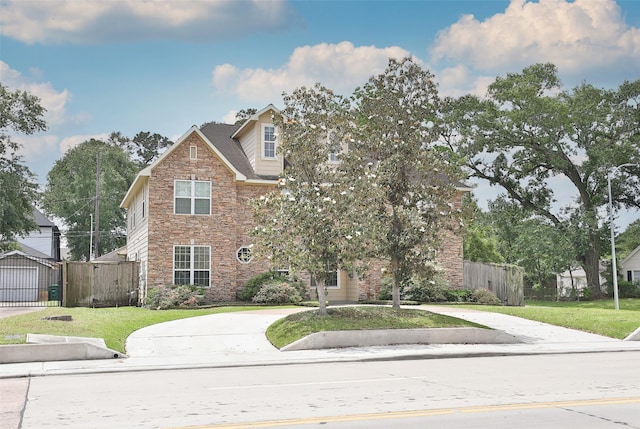 view of front of home with a gate, fence, driveway, and stone siding