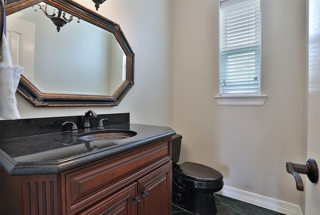 half bathroom featuring baseboards, vanity, toilet, and marble finish floor