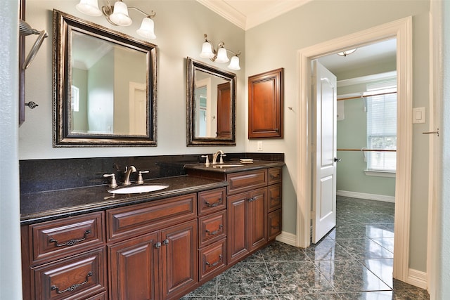 full bathroom featuring double vanity, baseboards, ornamental molding, and a sink