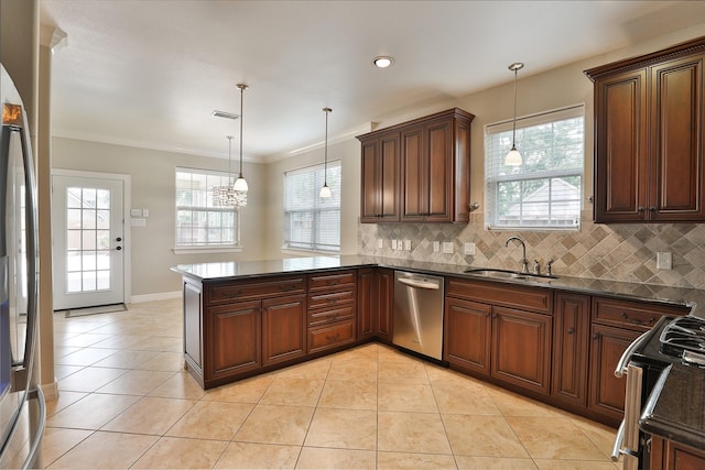 kitchen with appliances with stainless steel finishes, a sink, a peninsula, baseboards, and backsplash