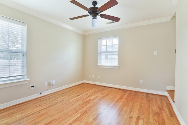 spare room featuring ceiling fan, visible vents, crown molding, light wood-type flooring, and baseboards