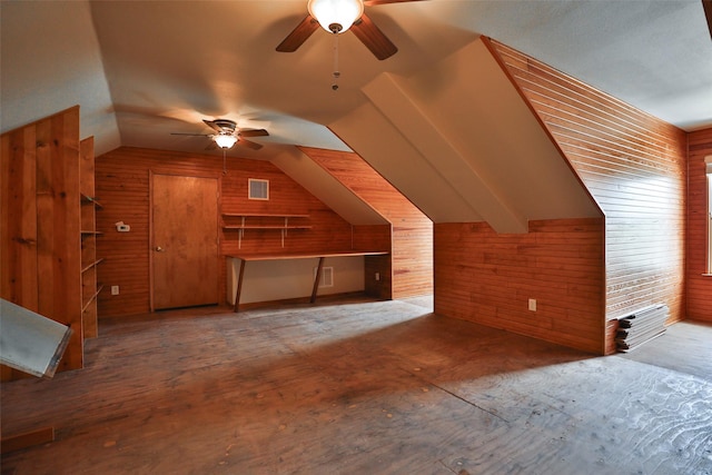 bonus room with visible vents, ceiling fan, wood walls, and vaulted ceiling