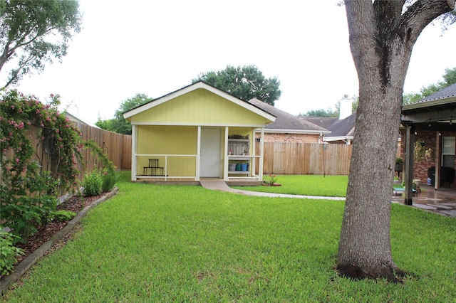 back of house with a porch, a fenced backyard, and a yard