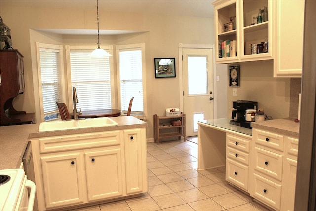 kitchen with a healthy amount of sunlight, stove, light countertops, a sink, and light tile patterned floors
