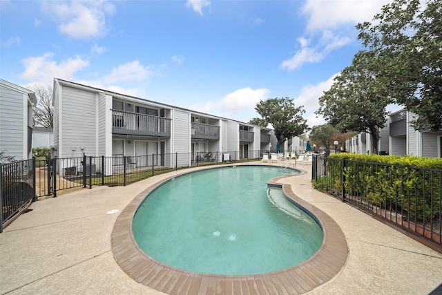 community pool featuring fence and a residential view