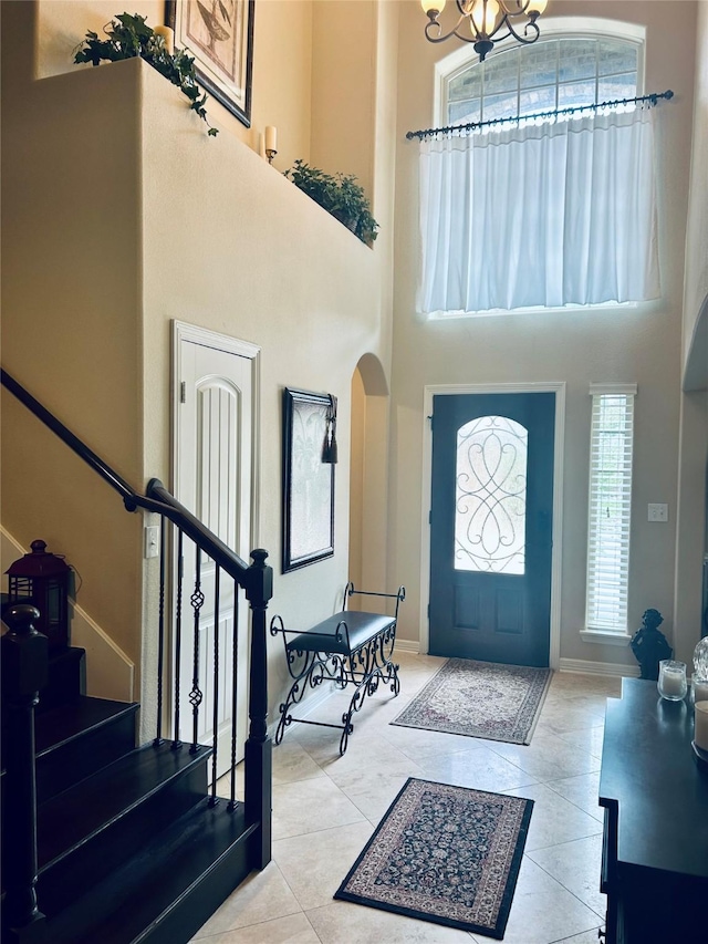 2731 Sea Ledge Dr, Seabrook, TX 77586 - tiled entrance foyer with arched walkways, a towering ceiling, stairs, a chandelier, and baseboards