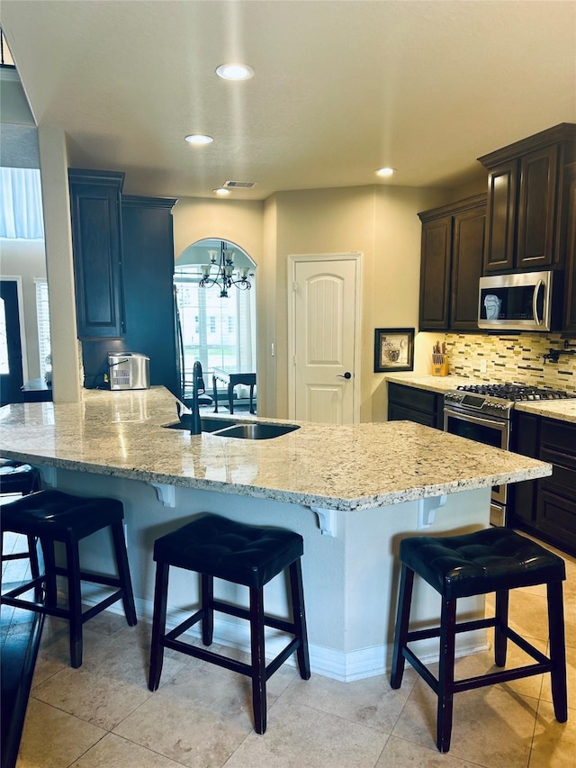 2731 Sea Ledge Dr, Seabrook, TX 77586 - kitchen featuring appliances with stainless steel finishes, a kitchen breakfast bar, recessed lighting, a sink, and tasteful backsplash