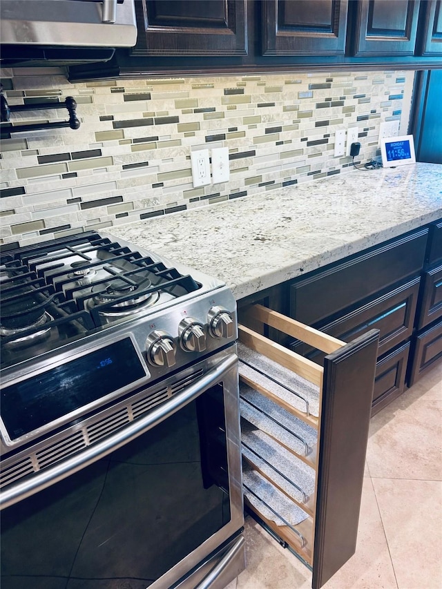 2731 Sea Ledge Dr, Seabrook, TX 77586 - kitchen with stainless steel gas range oven, decorative backsplash, light stone counters, and light tile patterned floors