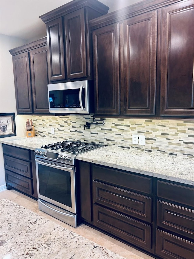 2731 Sea Ledge Dr, Seabrook, TX 77586 - kitchen featuring stainless steel appliances, light stone counters, backsplash, and light tile patterned floors