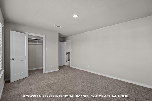 unfurnished bedroom with carpet floors, baseboards, a closet, and visible vents