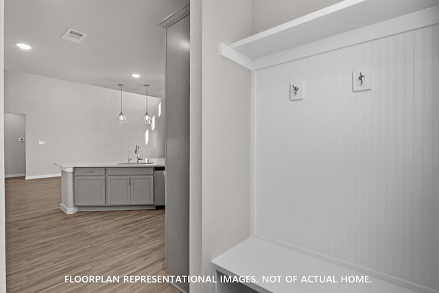 mudroom featuring visible vents, baseboards, recessed lighting, a sink, and light wood finished floors