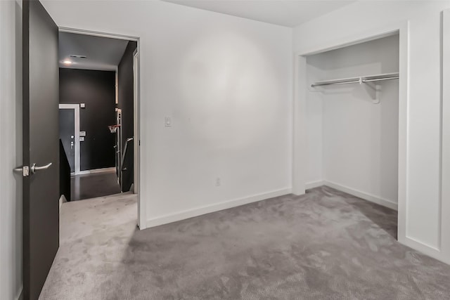 unfurnished bedroom featuring carpet floors, baseboards, and a closet