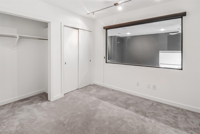 102 Quitman St Unit 301, Houston, TX 77009 - unfurnished bedroom featuring multiple closets, carpet, rail lighting, and baseboards